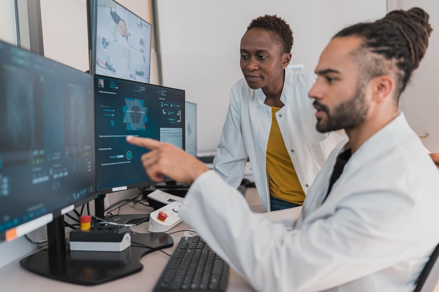 Two physicians looking at medical imaging on computer screens