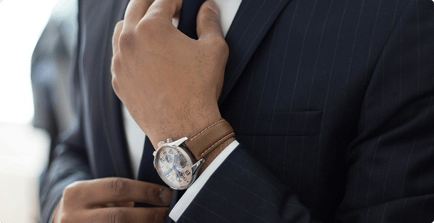 Close-up view of man wearing business suit and tie, adjusting tie
