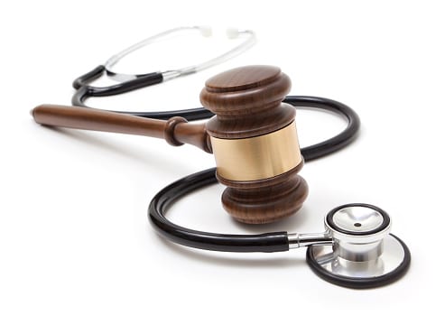 Stethoscope and gavel on white background.