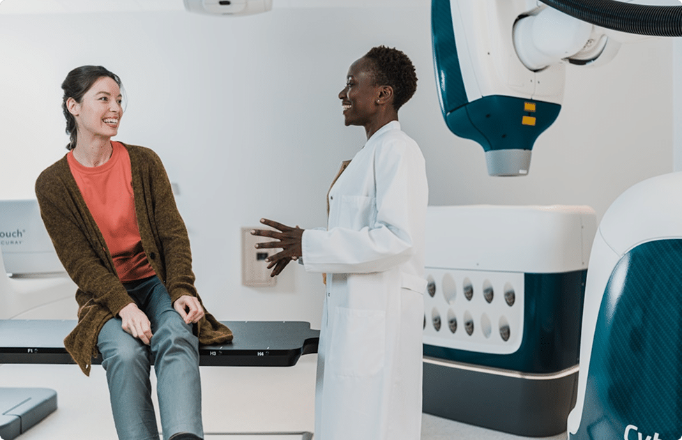 Female physician in room with woman prior to doing imaging